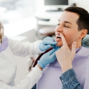 Dentist examining patient's mouth during oral exam in Jacksonville dental office.