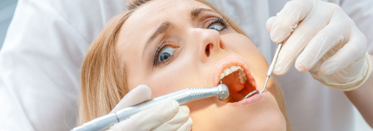Dental hygienist examining patient's teeth during professional cleaning appointment.