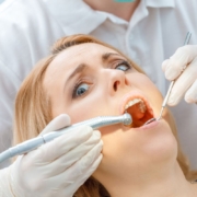 Dental hygienist examining patient's teeth during professional cleaning appointment.