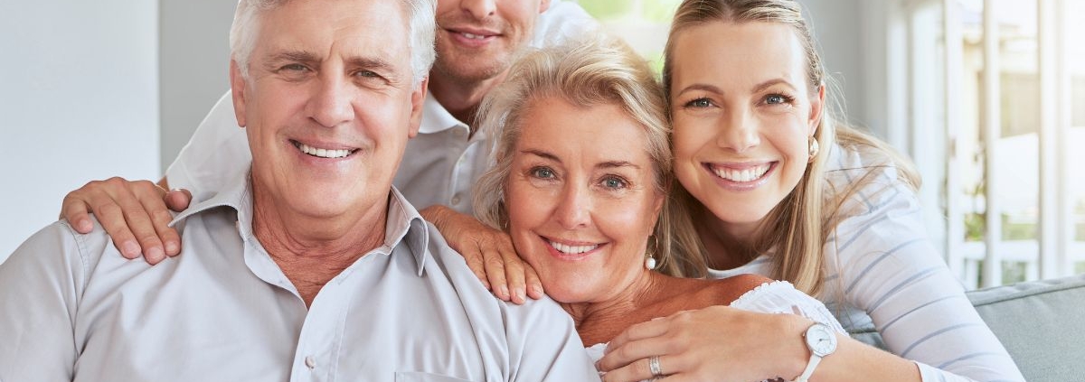 Happy multi-generational family smiling together in a bright home setting.