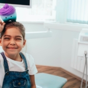 Happy child holding colorful toy in Jacksonville pediatric dental office.