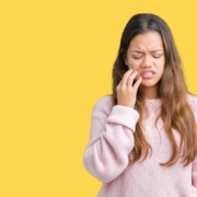 Woman with tooth pain touching her cheek, showing gum disease symptoms.