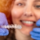 Dentist holding a clear Invisalign aligner during a patient consultation.