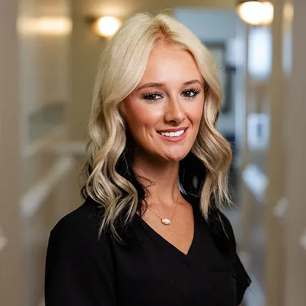 img-makenna-antinori Team member smiling in Jacksonville dental practice hallway.