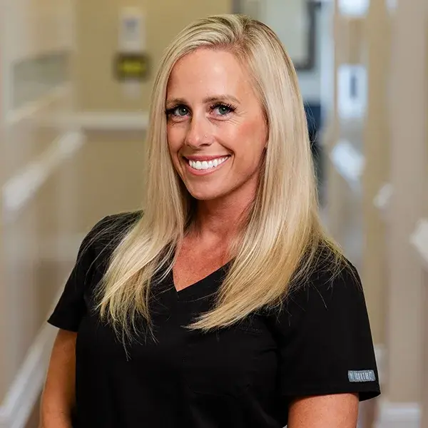 img-samantha-breeding Blonde female dental team member smiling in professional black scrubs.