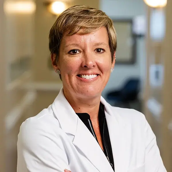 img-whitney-mitchell Female dentist smiling in white coat at Jacksonville dental practice.